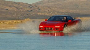 A first-generation Acura NSX driving through water