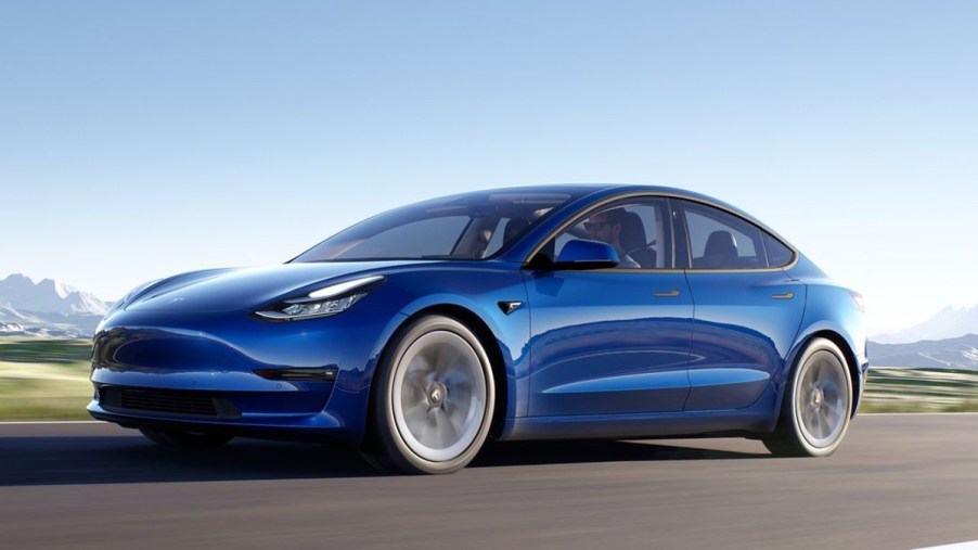 Blue 2022 Tesla Model 3 on a road