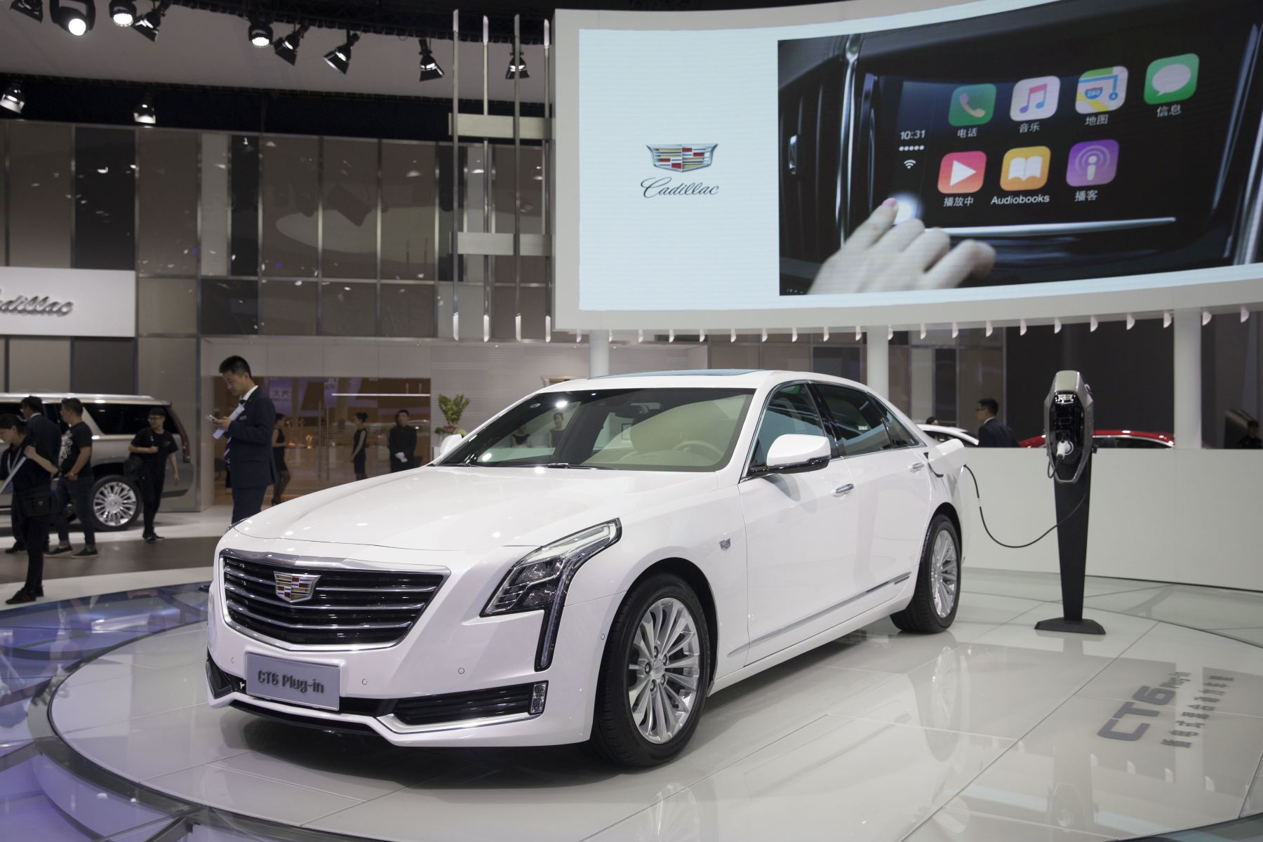 A white Cadillac CT6 plug-in hybrid (PHEV) plugged into a charging station at Auto Shanghai 2017