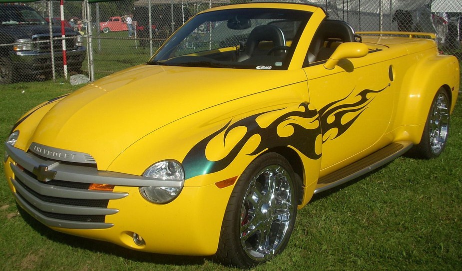 A yellow Chevy SSR pickup truck with flames on its side.