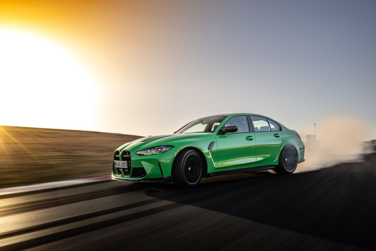 The 2024 BMW M3 CS in green drifting on a track in the evening. 