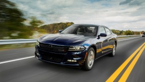 The 2023 Dodge Charger SXT shows off its performance four-door car credentials by blasting down a highway.
