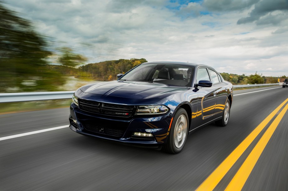 The 2023 Dodge Charger SXT shows off its performance four-door car credentials by blasting down a highway. 