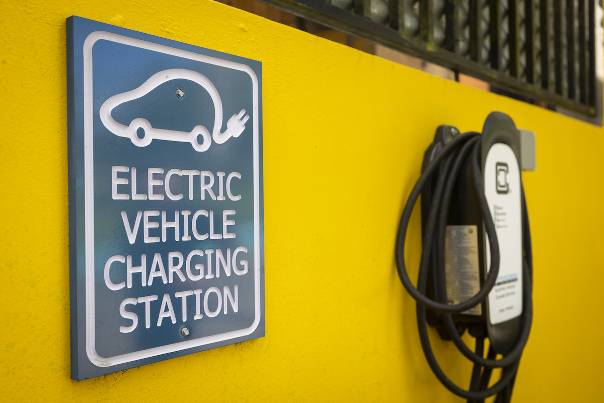 A yellow wall with an electric charging station, which is to an EV that doesn't need a transfer case.