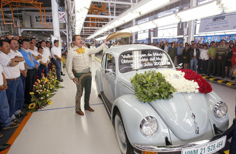 A mariachi singer places his sombrero on top of the final classic VW Beetle ever built, on the factory line in Pueblo, Mexico.