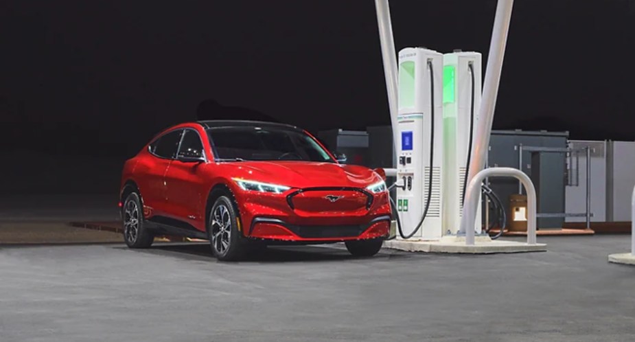 A red Ford Mustang Mach-E small electric SUV is charging. 