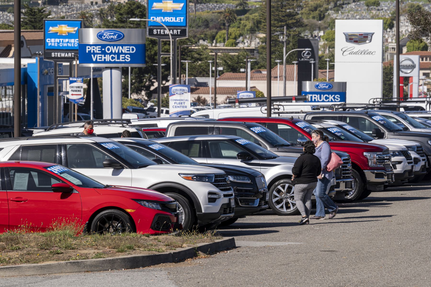 Car shoppers roaming Ford and Cadillac car sales dealerships in Colma, California