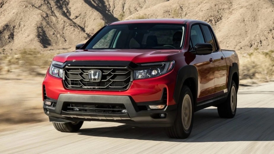 Front angle view of red 2023 Honda Ridgeline, only Consumer Reports recommended midsize pickup truck due to reliability