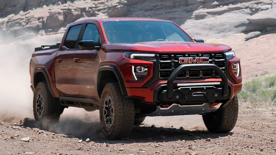 Front angle view of red 2023 GMC Canyon pickup truck, which is better than 2022 model with its redesign