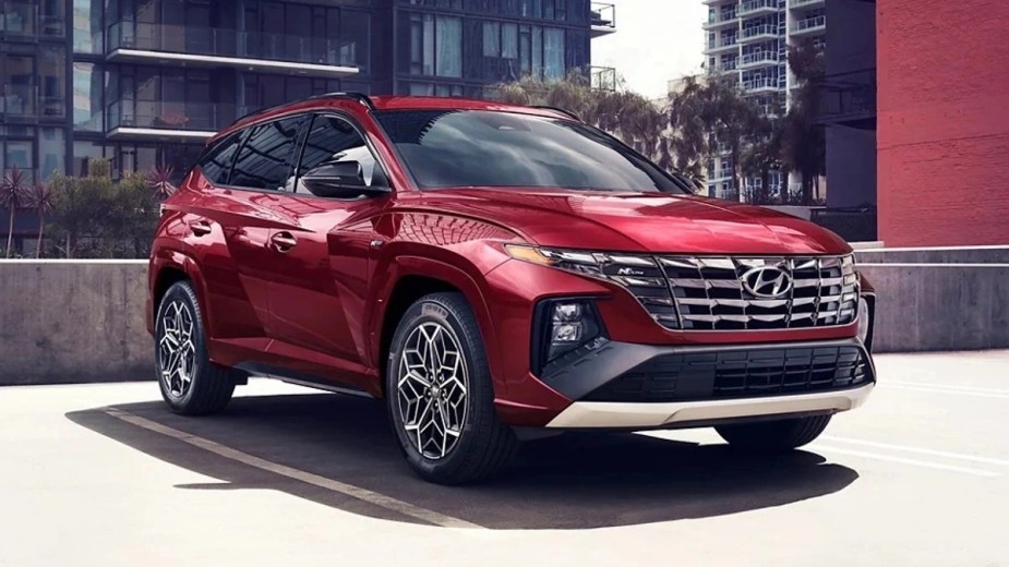 Front angle view of red 2023 Hyundai Tucson, showing which car brand is cheaper: Hyundai or Kia?