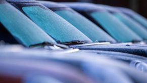 Cars in a parking lot with icy windshields.