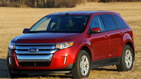 A red 2012 Ford Edge parked outside on grass, it's a Ford SUV model year to avoid