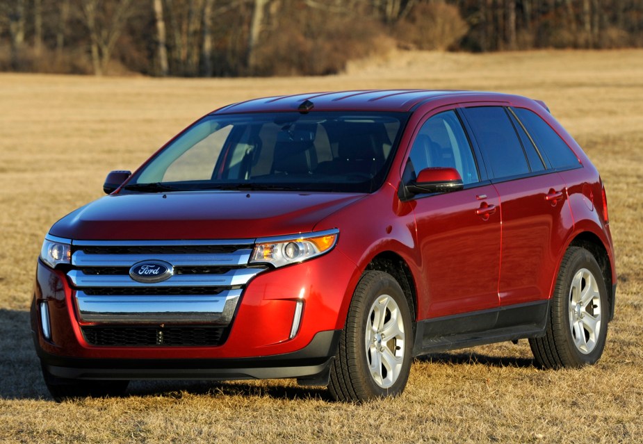 A red 2012 Ford Edge parked outside on grass, it's a Ford SUV model year to avoid