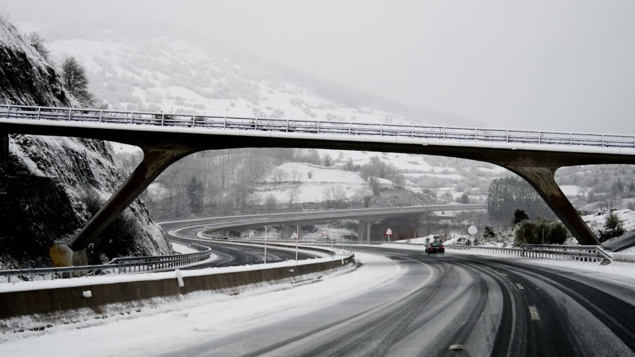 A snow-covered road under a bridge