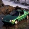 A green Honda Del Sol showing off its targa top option in a scenic natural area