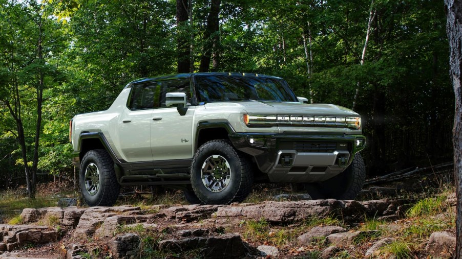 A green 2023 GMC Hummer EV electric pickup truck is parked outside.