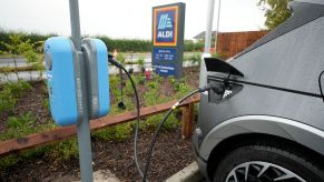 A Hyundai Ioniq 5 electric vehicle (EV) plugged into a charging station at an Aldi supermarket/grocery store