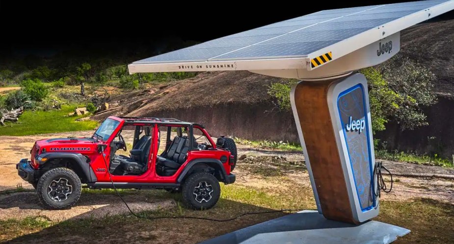 A red 2023 Jeep Wrangler 4xe small plug-in hybrid is charging. 