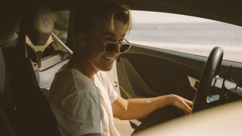 Man with sunglasses sitting in a car, highlighting how operating a motor vehicle affects intelligence