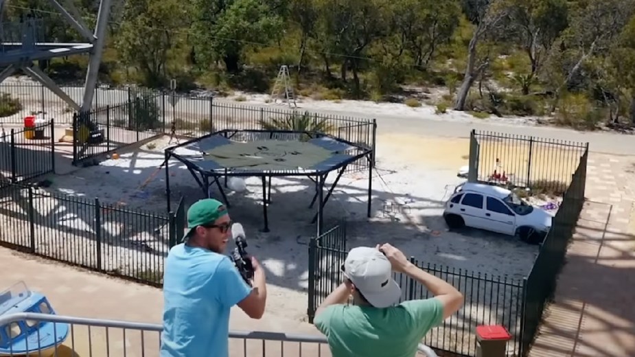 Mark Rober and another man celebrating after car survives bouncing off a trampoline