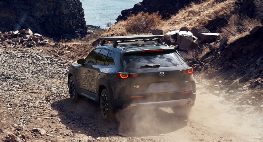 The blue 2023 Mazda CX-Turbo small SUV is driving off-road. 