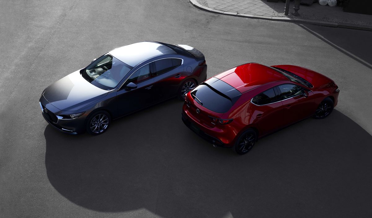 Two Mazda3 models parked side by side on a street.