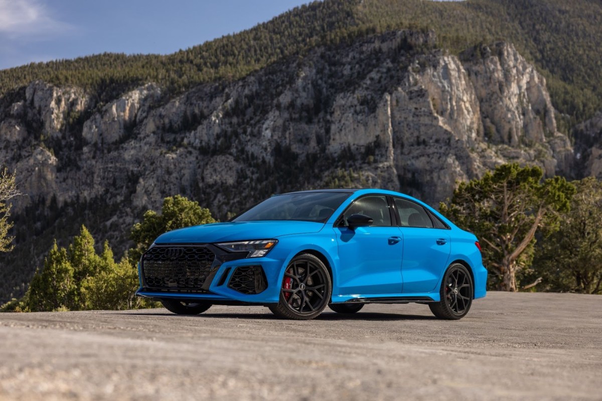 A 2023 Audi RS 3 in blue parked by a mountain