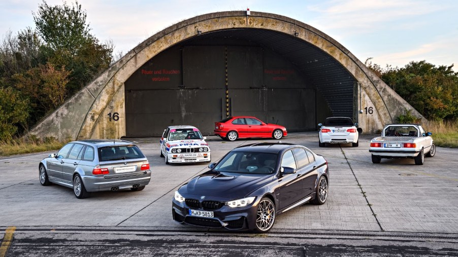 Generations of BMW M3 models near a hangar