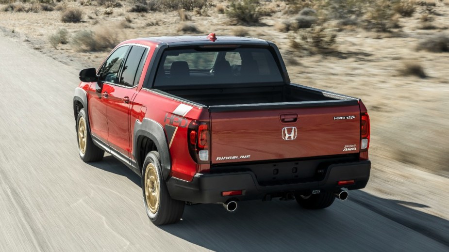 Rear angle view of a red 2023 Honda Ridgeline midsize pickup truck