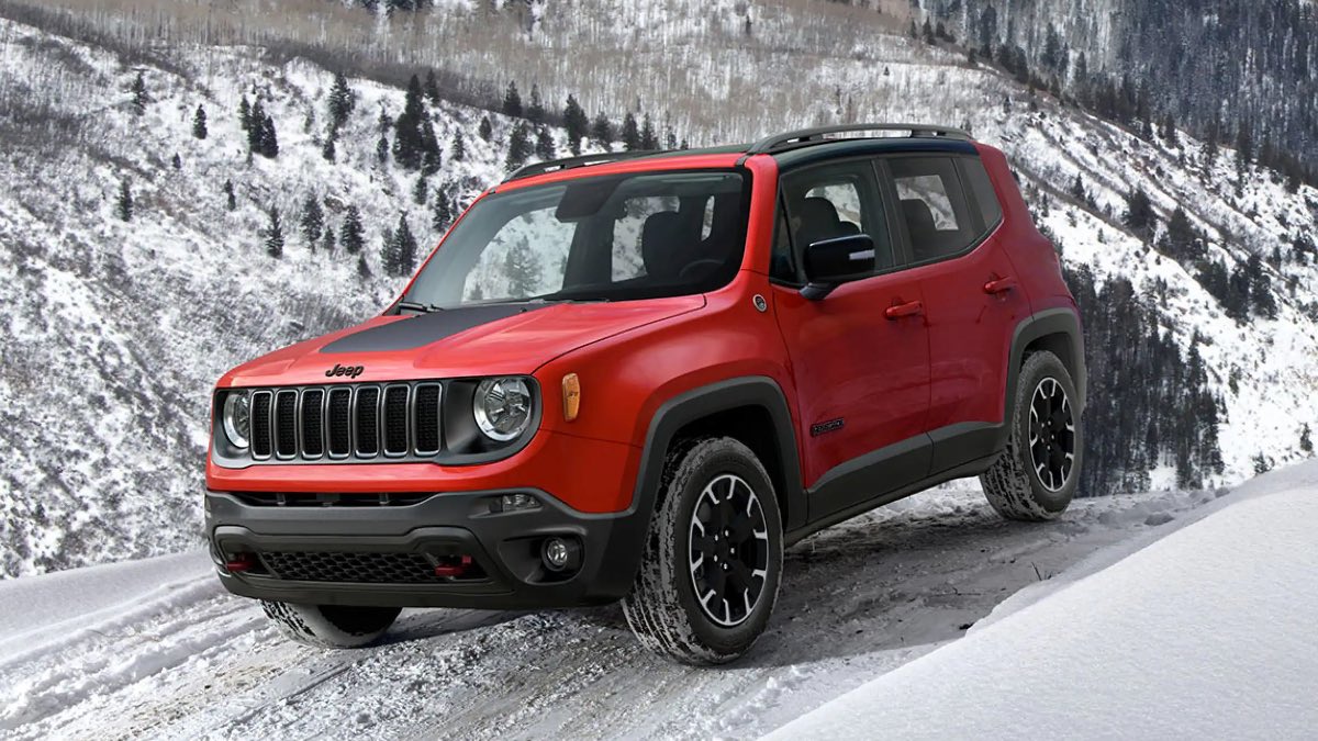 Red 2023 Jeep Renegade small SUV, the cheapest new Jeep, driving on snowy terrain