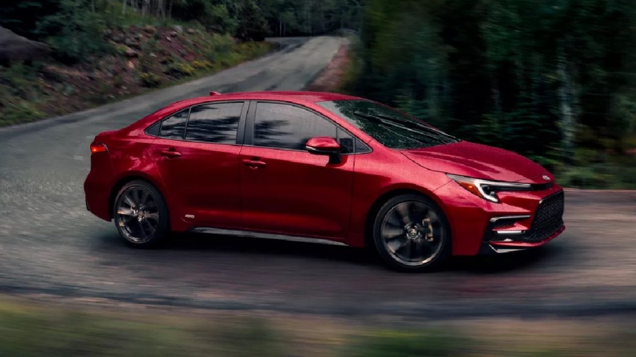 Red 2023 Toyota Corolla, Consumer Reports reliable car, driving on curvy road, showing why Toyota cars are so reliable