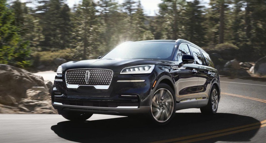 2023 Lincoln Aviator driving on a road during the day, price, features, engine, and more.
