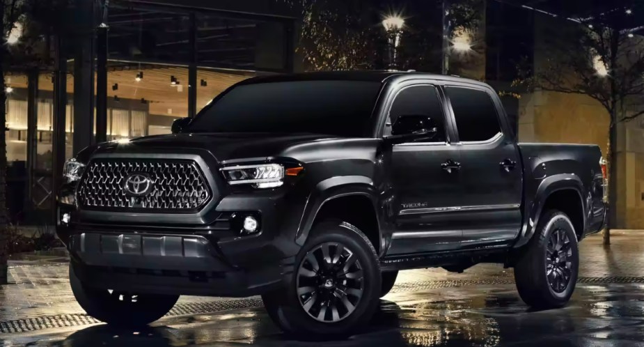 A black 2023 Toyota Tacoma midsize pickup truck is parked. 
