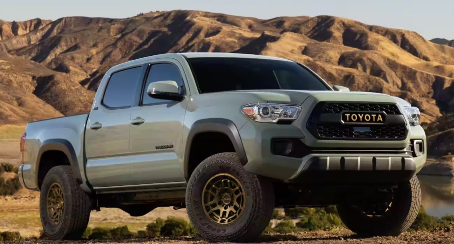 A green 2023 Toyota Tacoma midsize pickup truck is parked. 