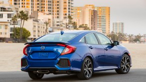 A used Honda Civic shows off its four-door car styling on a beach.