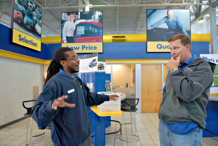 A CarMax sales person talks to a customer.