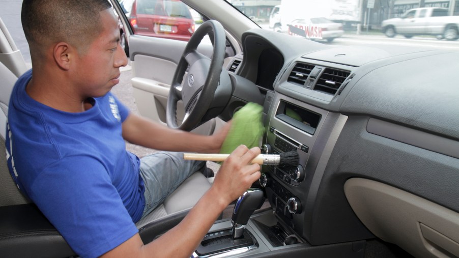 A man cleaning the interior of a car.