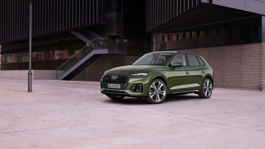 A green Audi Q5 compact luxury SUV parked near a lamppost