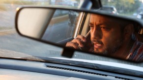 A man talks on the phone while driving