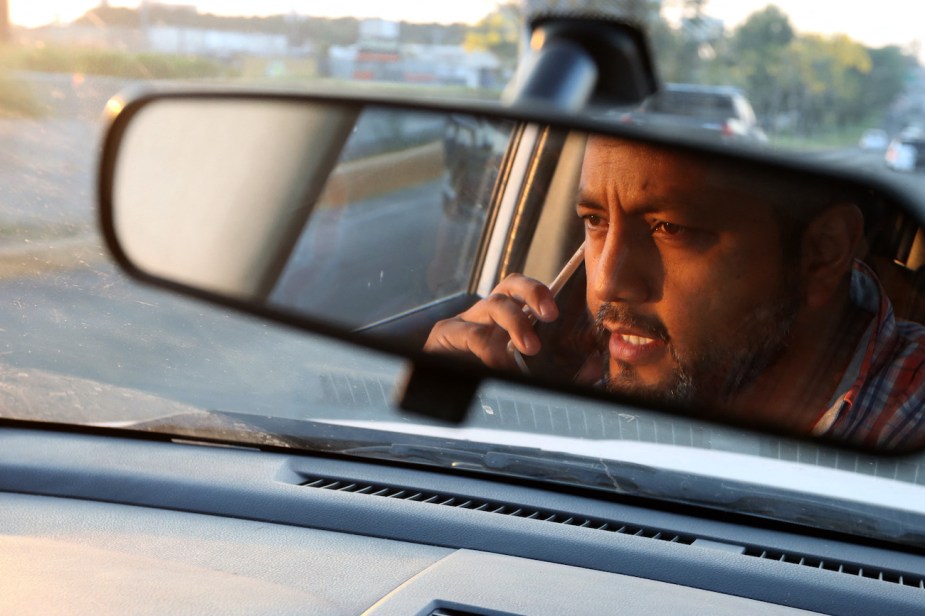 A man talks on the phone while driving