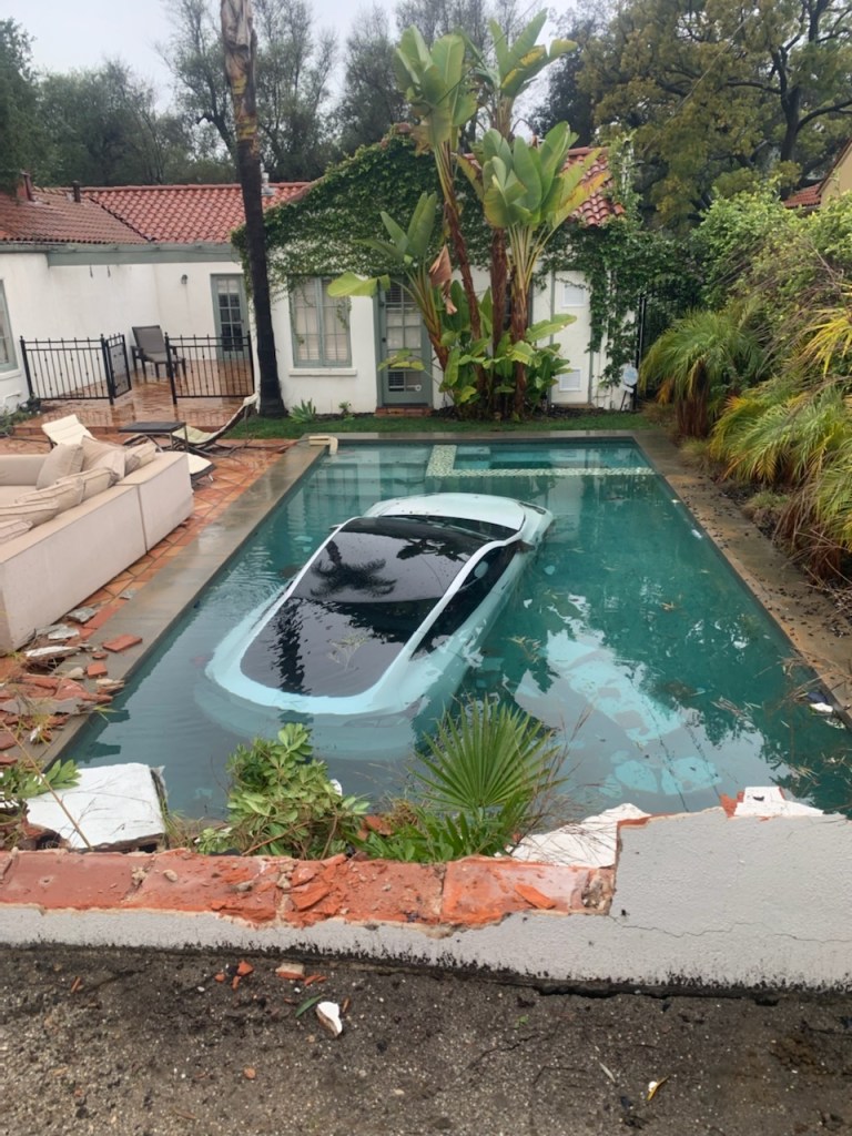 A Tesla vehicle is submerged in a swimming pool.