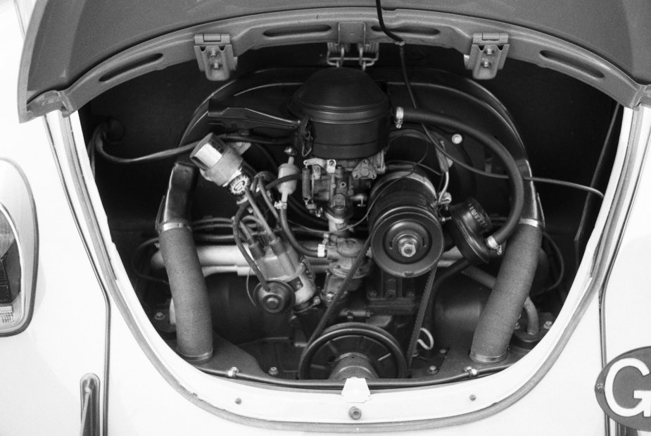 The engine bay of a vintage Volkswagen Beetle, with its air cooled flat-foor engine visible.