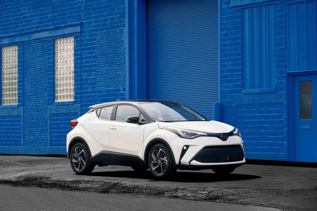 A white 2022 Toyota C-HR subcompact SUV model framed by a blue-painted brick wall