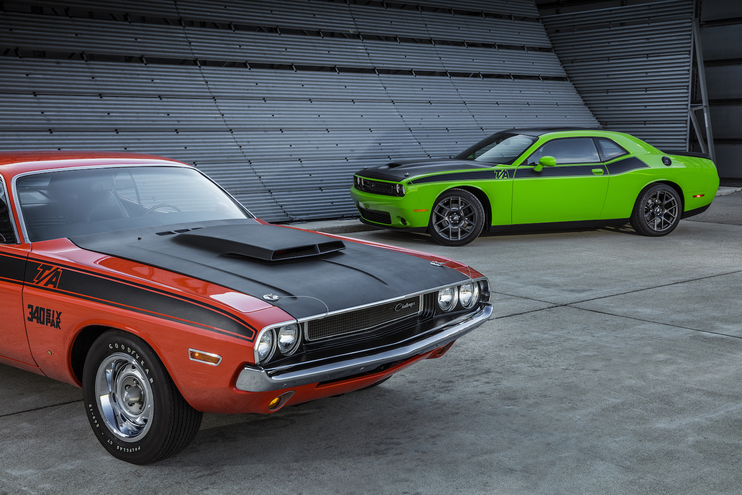 A red vintage Dodge Challenger is parked next to a new, green version of the T/A trim for a promo photo.