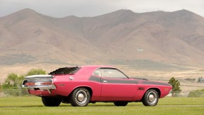 Reddish pink 1970 Dodge Challenger rare T/A Trans America trim parked in front of a mountain ridge.