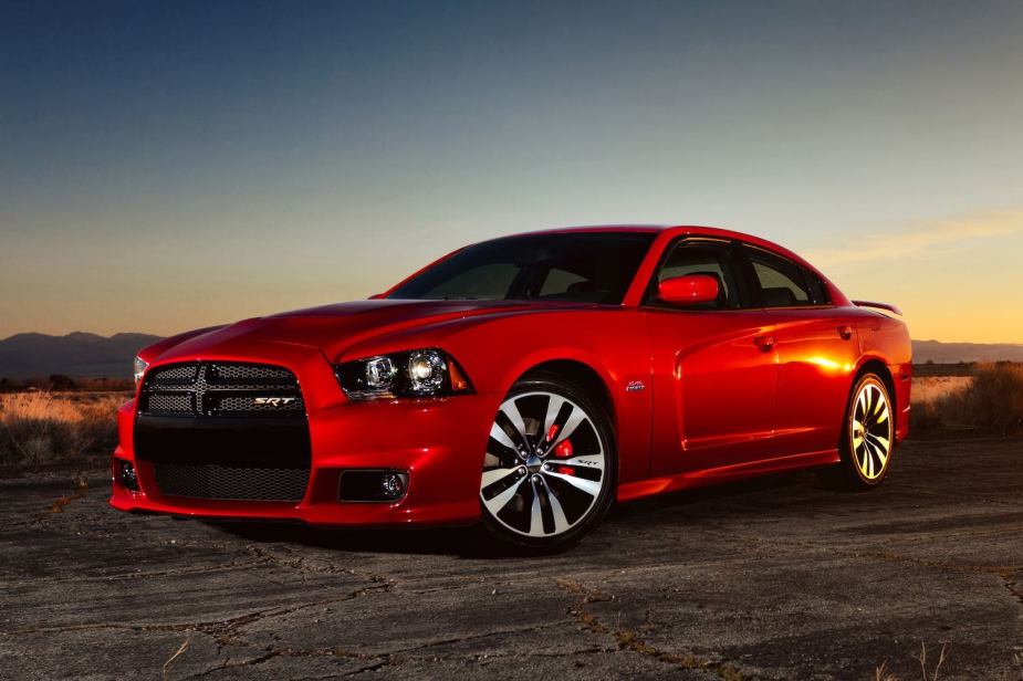 Promo photo of a red 2013 Dodge Charger SRT8 which had an MSRP price of just $46k, a sunset visible in the background.