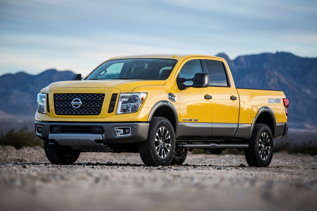 a yellow nissan titan is in front of mountains