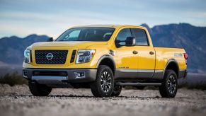 a yellow nissan titan is in front of mountains