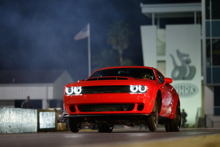 A Dodge Challenger SRT Demon does a wheelie at a drag strip.