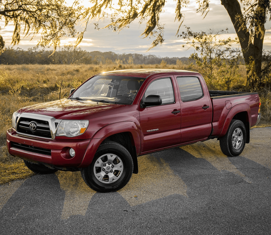 A red 2018 Toyota Tacoma parked under a tree